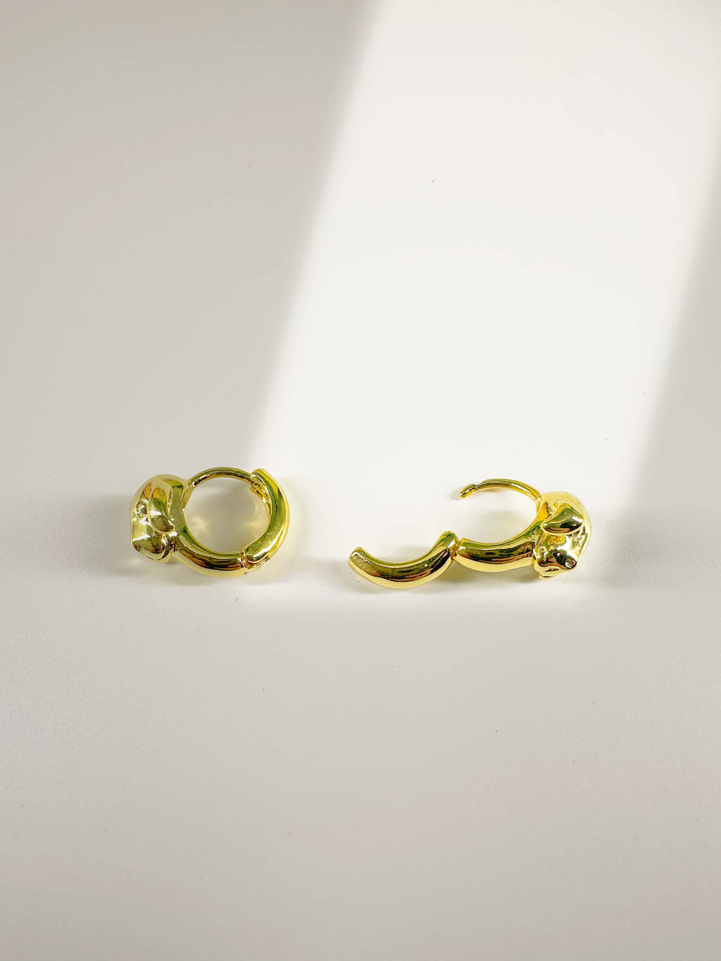 Detailed view of the open and closed snap-lock clasp mechanism of the 18K gold dog earring