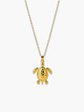 A high-quality studio shot of a polished 18K gold sea turtle necklace pendant against a clean, light gray background