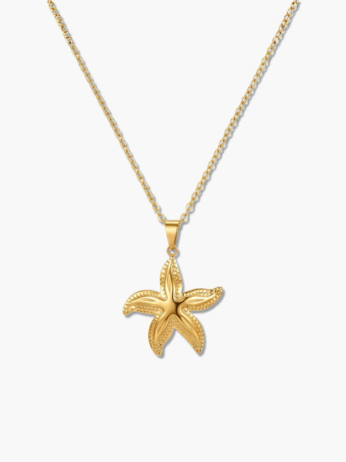A detailed product shot of an 18K gold starfish necklace with an intricately textured star pendant on a delicate gold chain over a white background