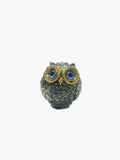 Decorative owl figurine with blue eyes on a white background