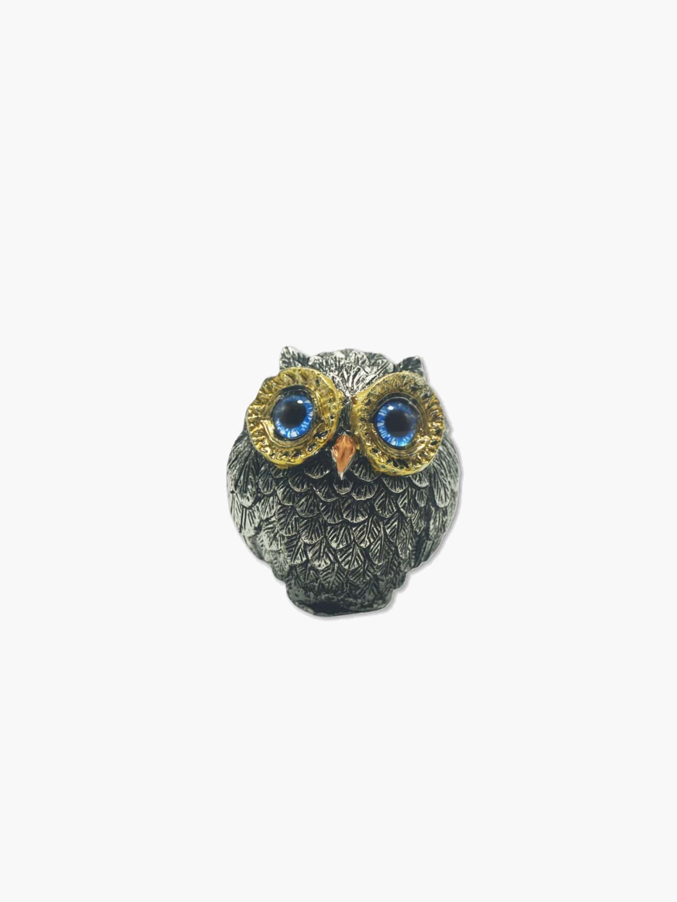 Decorative owl figurine with blue eyes on a white background