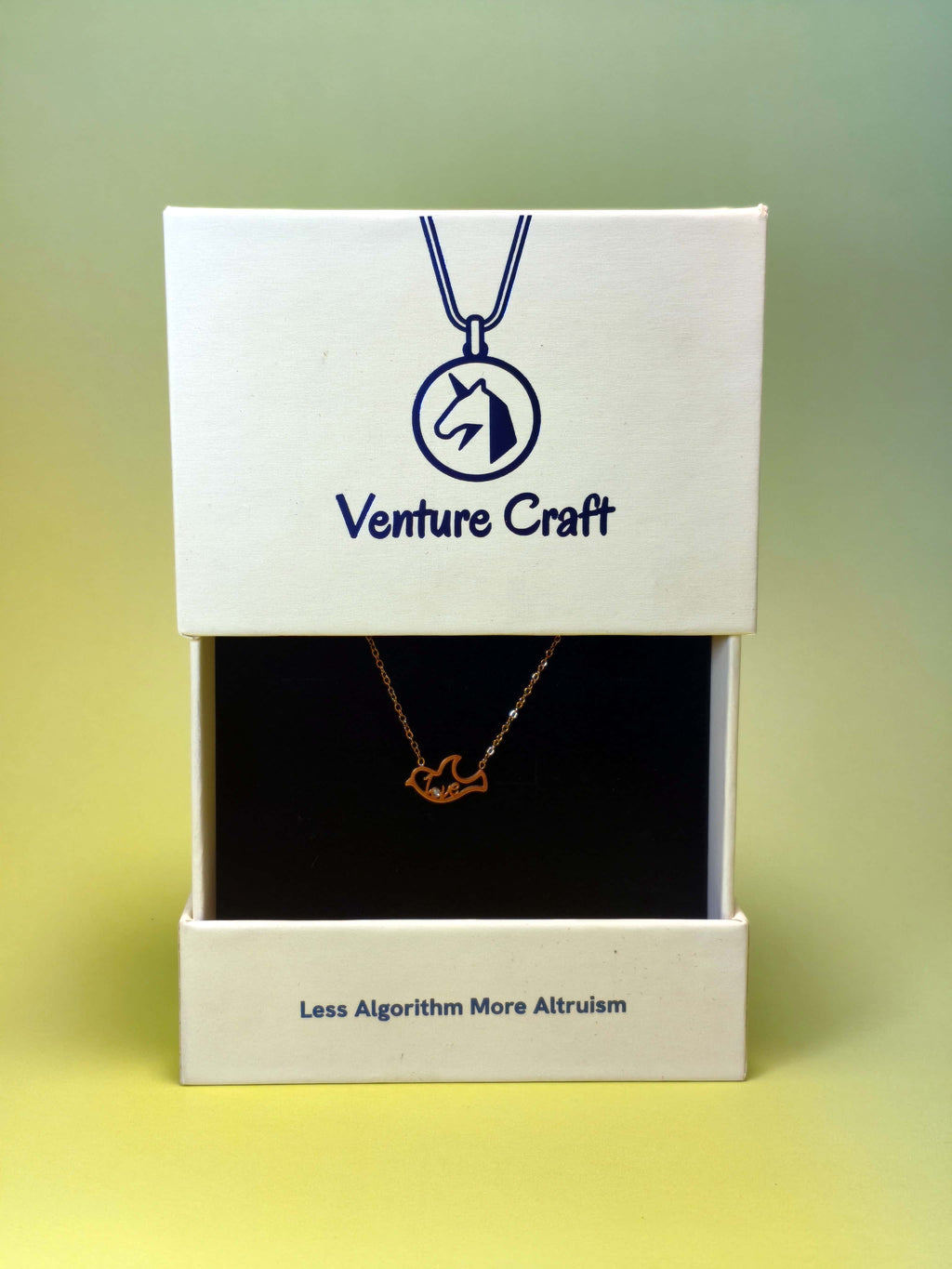 Dove-shaped necklace in a Venture Craft gift box on a gradient background