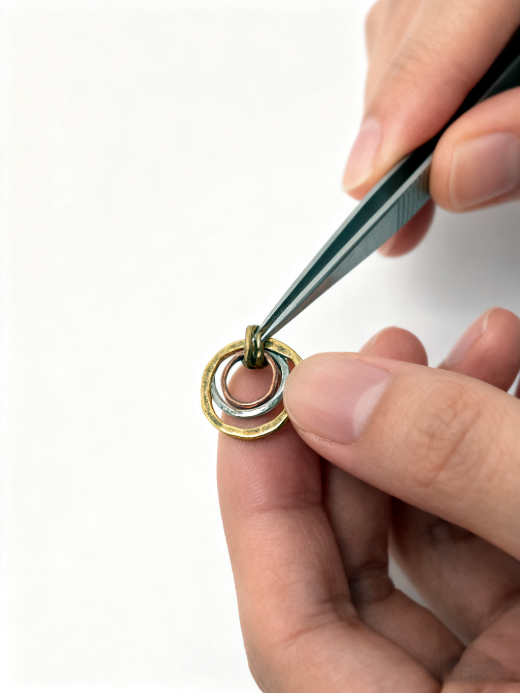 Close-up of a hand using tweezers to handle a small mechanical component on a white background