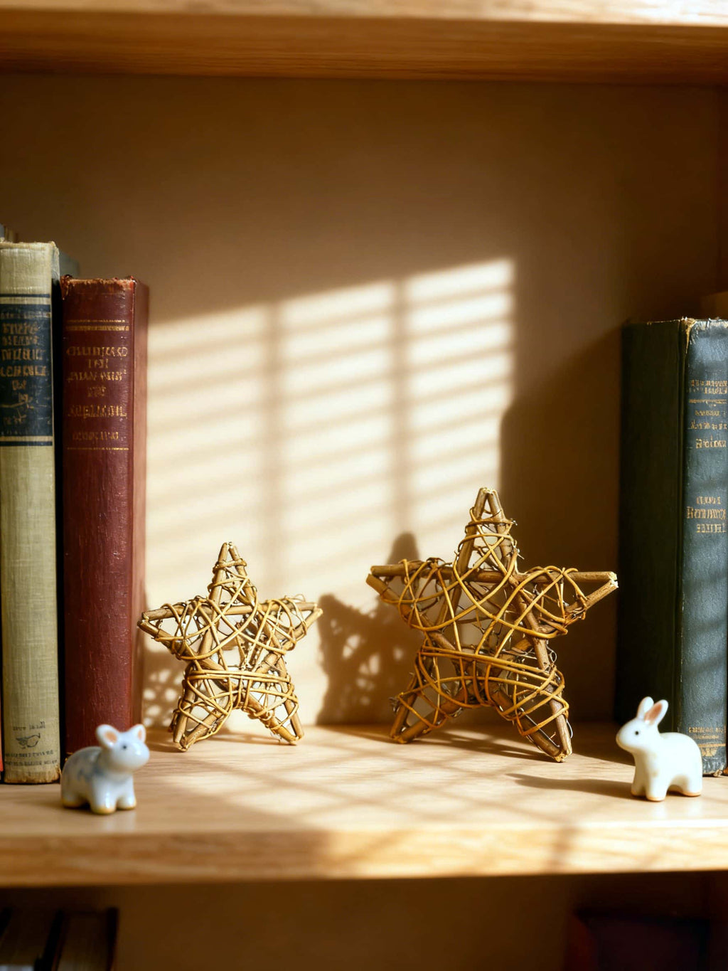 Decorative star-shaped objects on a shelf with books and small figurines.