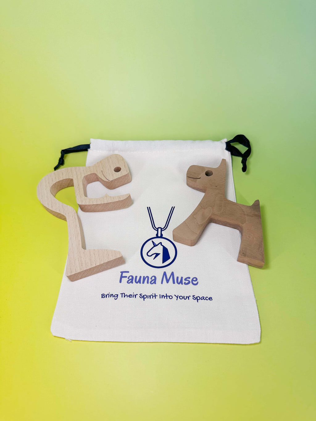 Two wooden animal-shaped pendant keepsakes, one horse and one deer, displayed on a white drawstring bag with the Fauna Muse logo, set against a yellow-green gradient background.