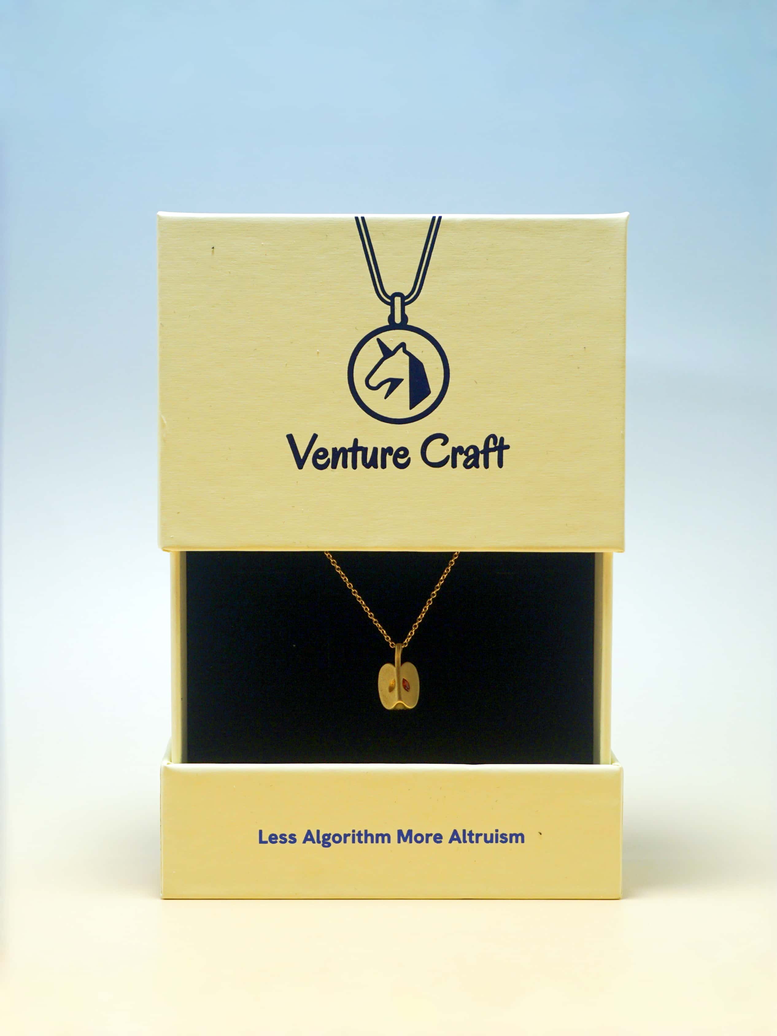 Venture Craft necklace in packaging with a blue gradient background