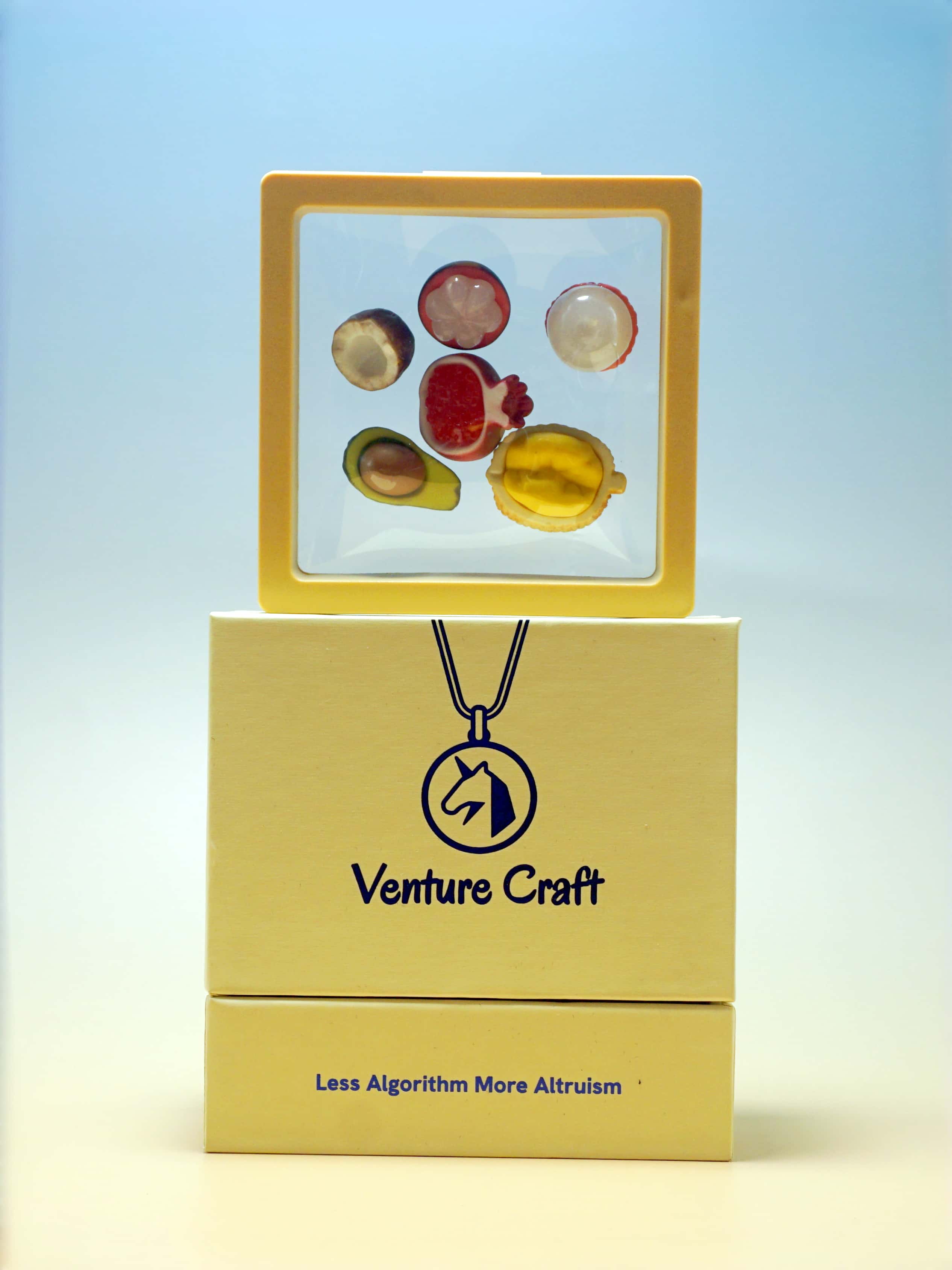 Venture Craft jewelry set with necklace and colorful pendants on a light blue background