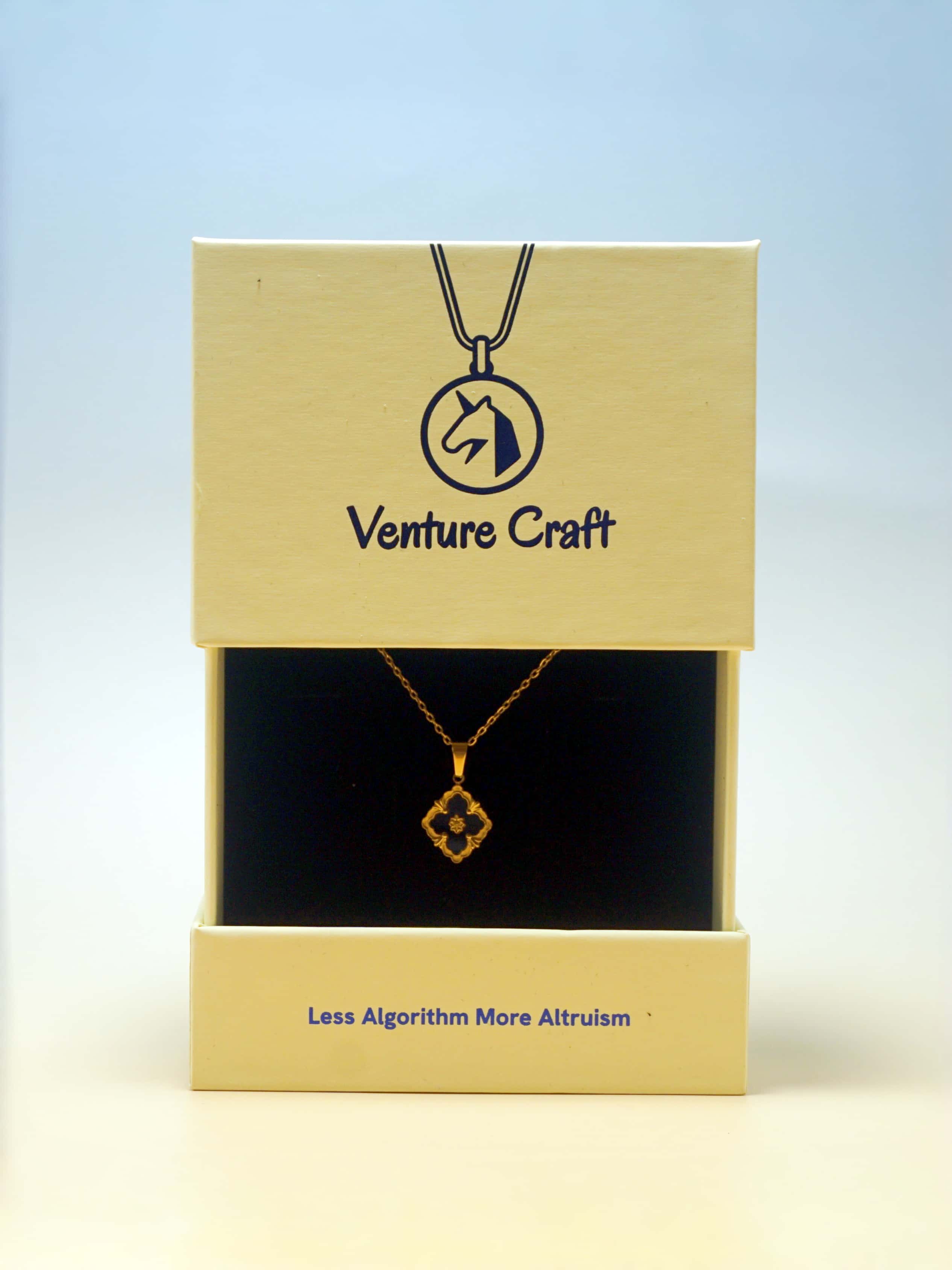 Gold necklace in a 'Venture Craft' box with a blue gradient background