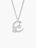 Detailed view of a silver cat moon necklace featuring a feline figure resting on a zircon-studded crescent moon, reaching toward a star-shaped moonstone.