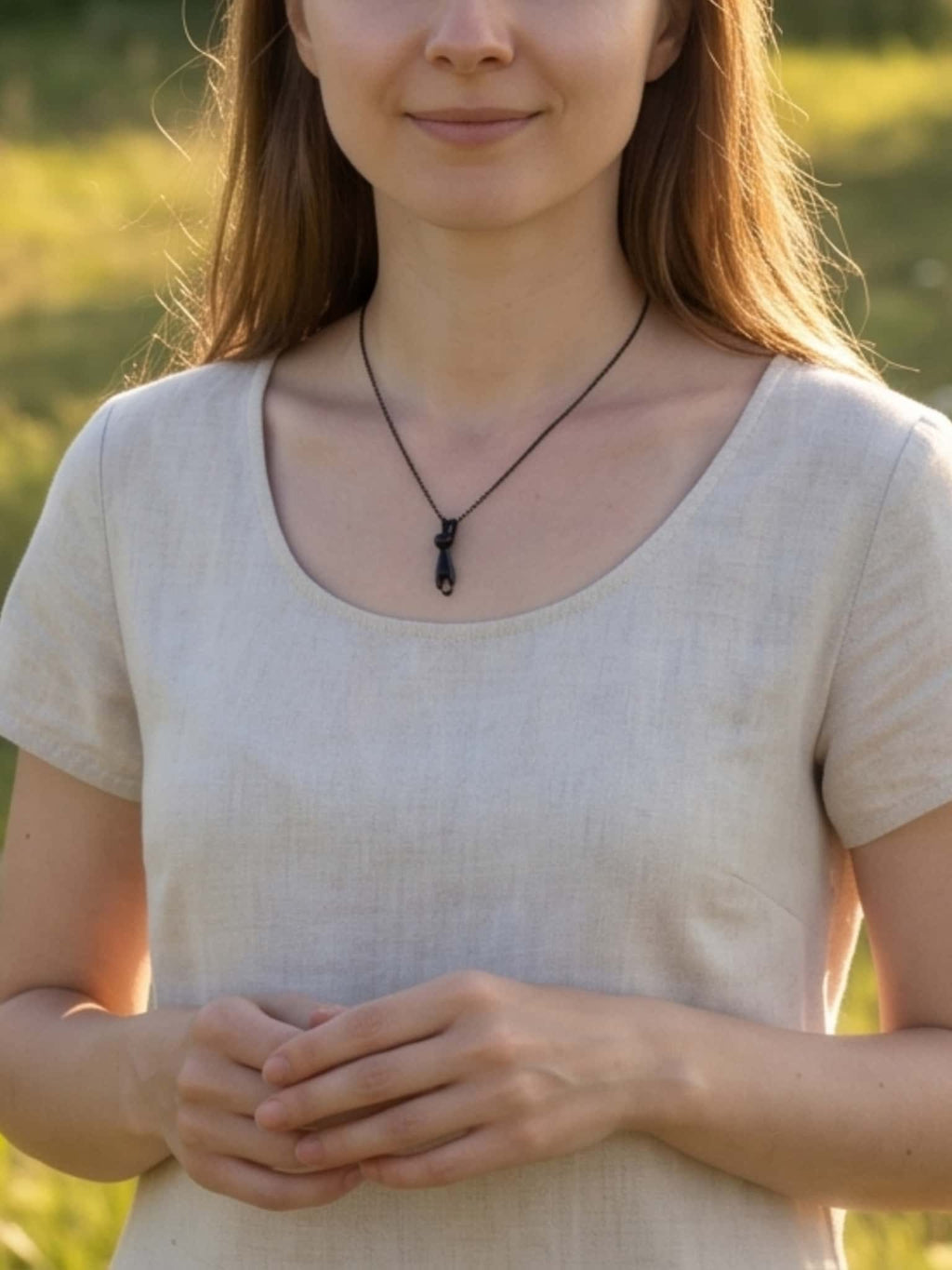 Lifestyle shot of a woman outdoors wearing a versatile stainless steel cat pendant necklace