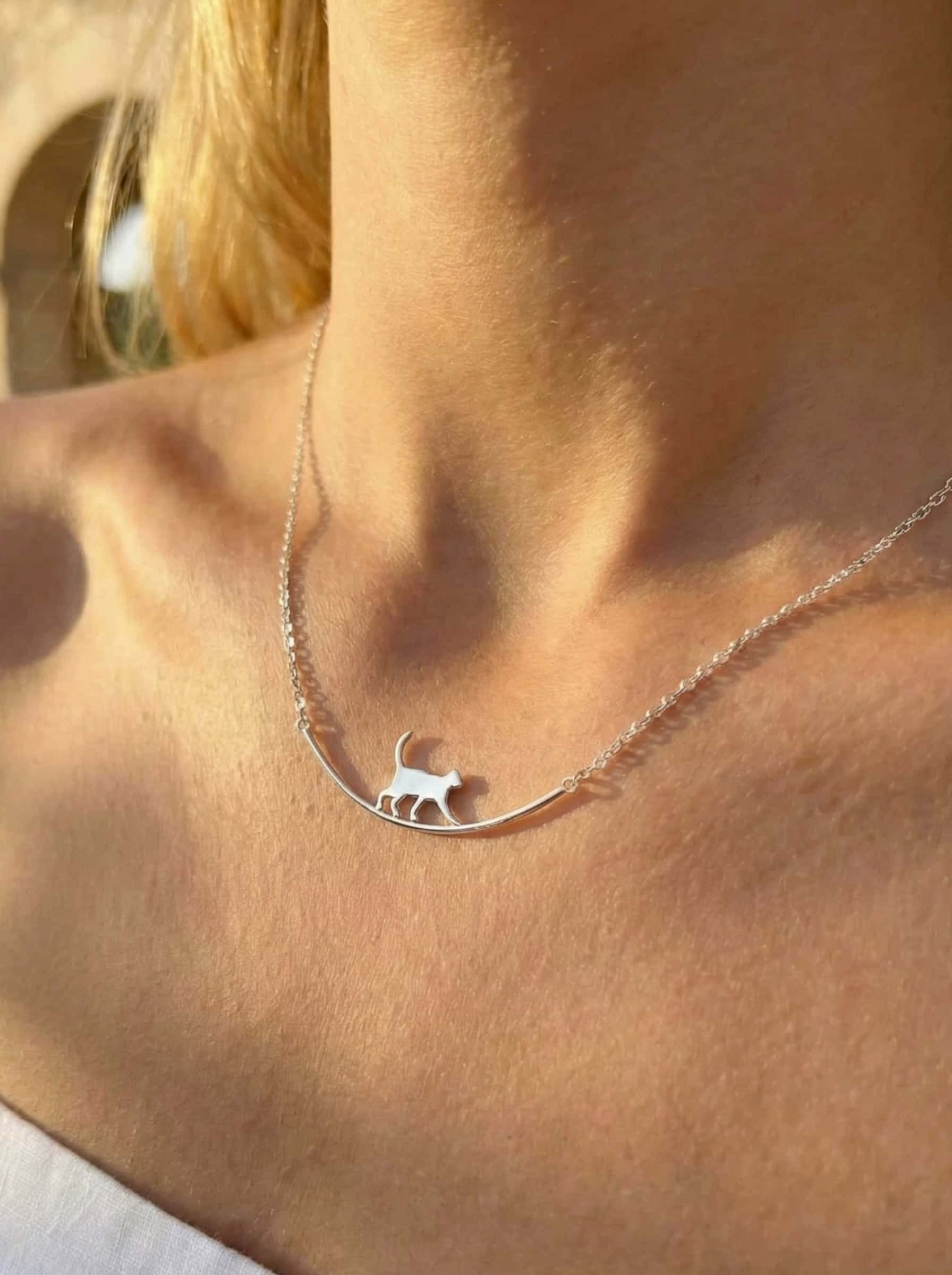 Necklace with a cat pendant worn by a person