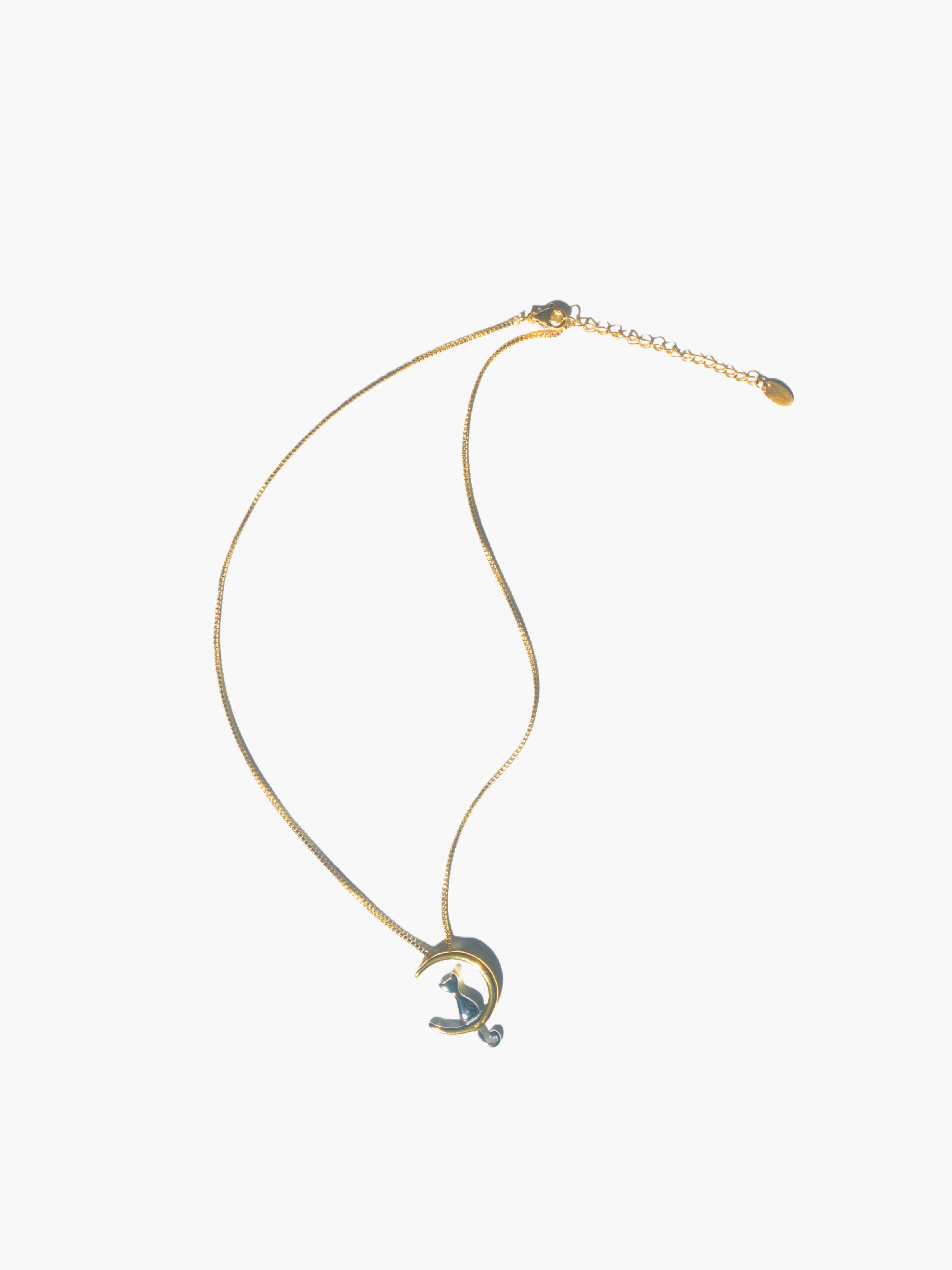 Gold necklace with a unique cat moon pendant on a white background