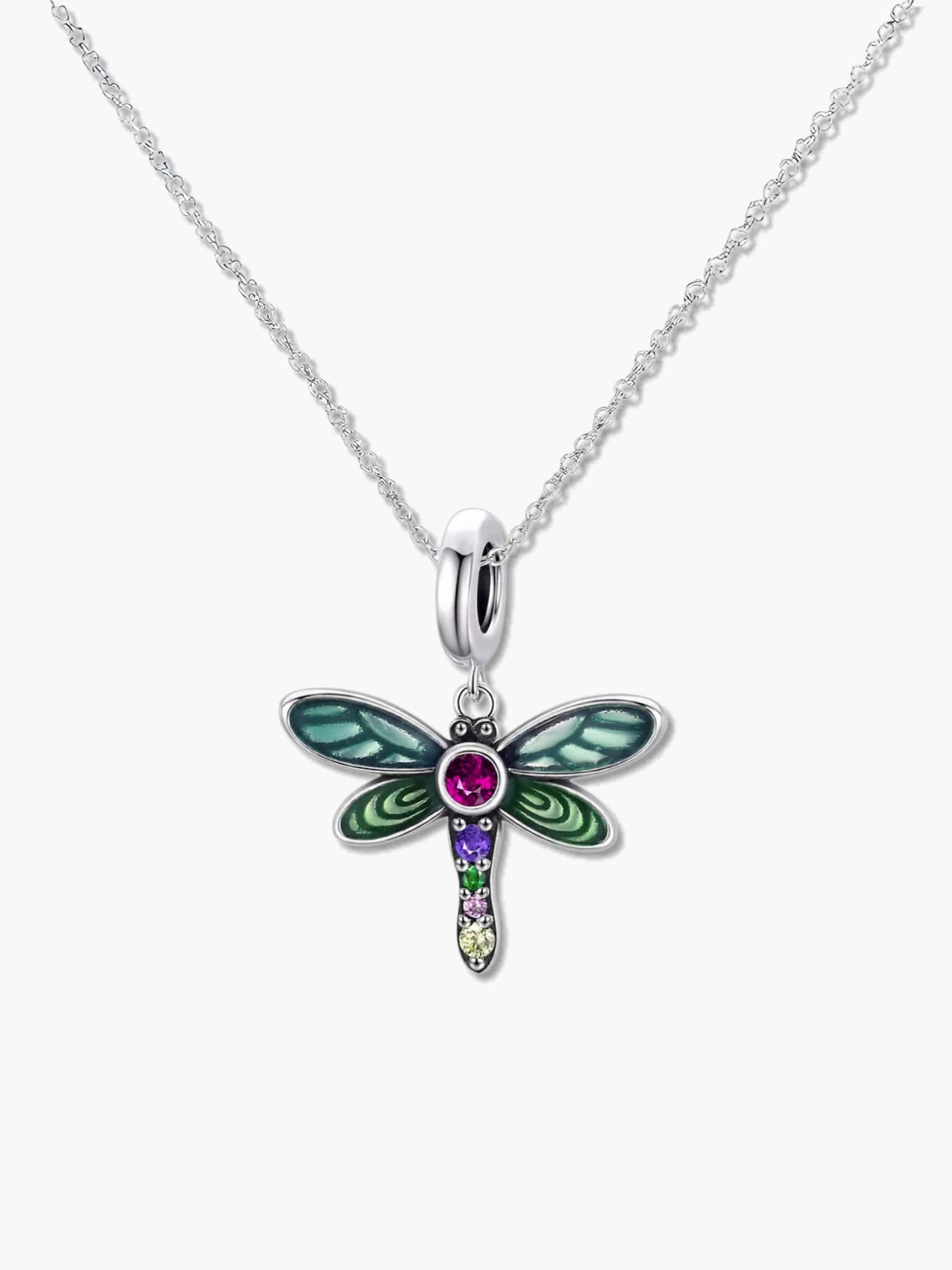 A high-quality studio shot of a dragonfly pendant necklace with vibrant green enamel wings and multi-colored cubic zirconia gemstones on a silver chain