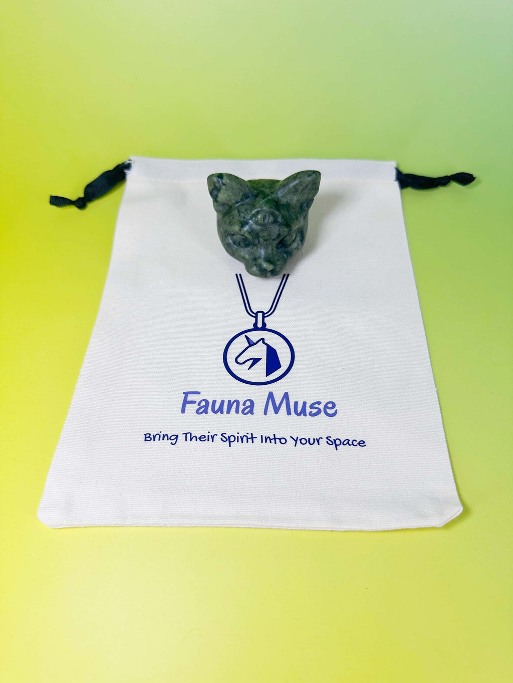 Carved crystal cat figurine presented on a branded Fauna Muse organic cotton drawstring gift pouch