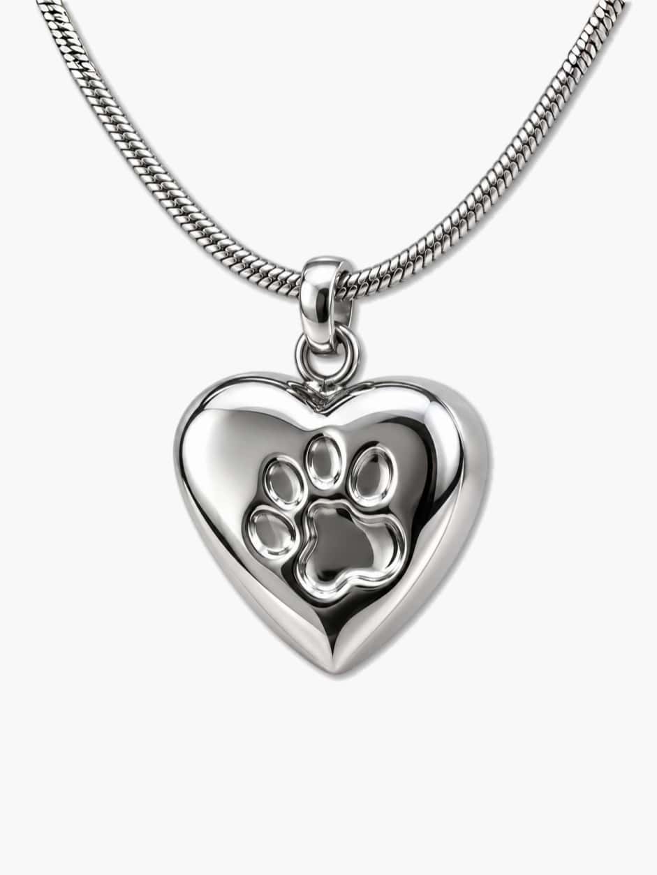 Polished heart-shaped dog ashes necklace with a paw print design and matching chain on a white background