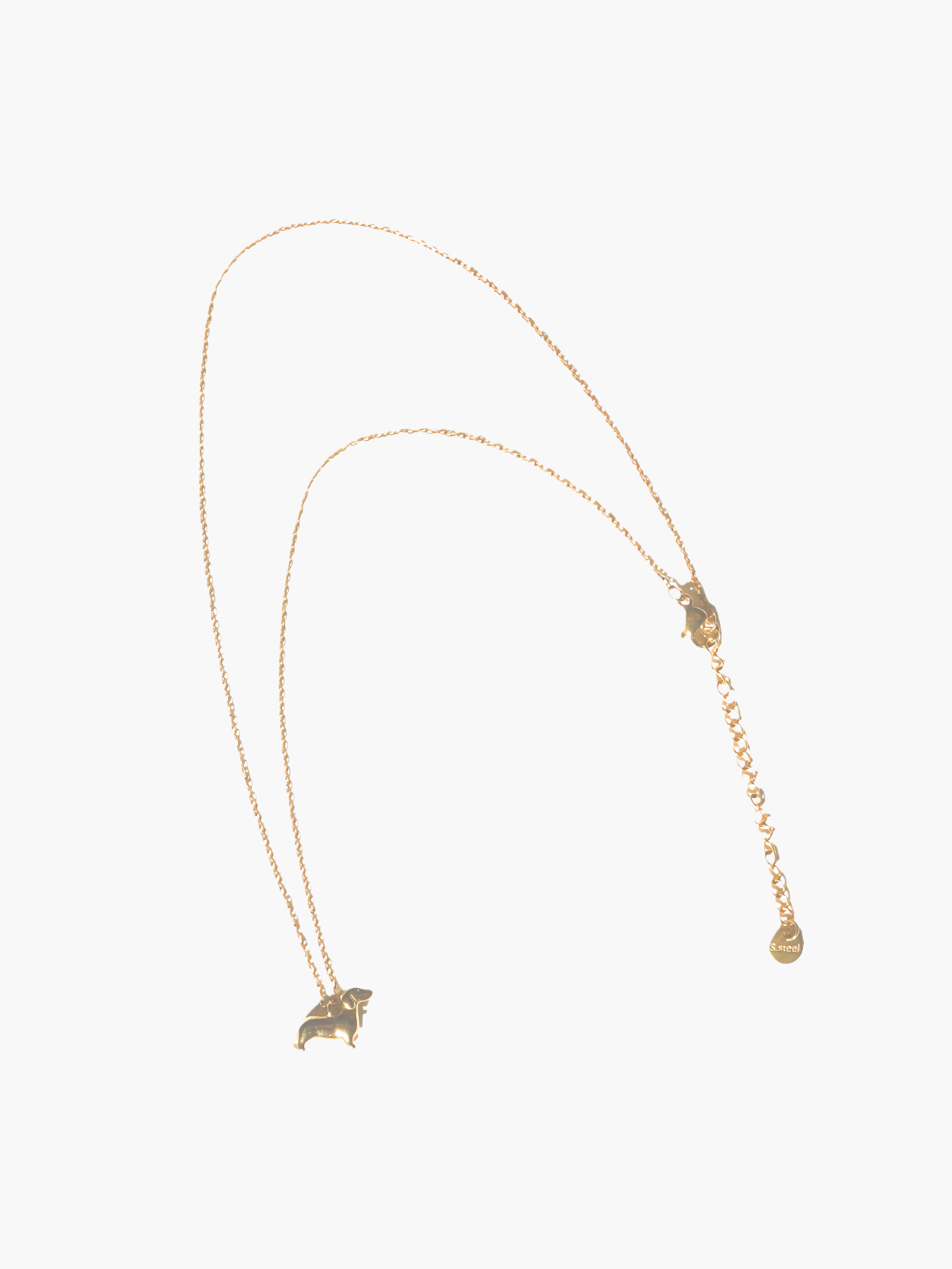 Gold necklace with a small dog-shaped pendant on a white background