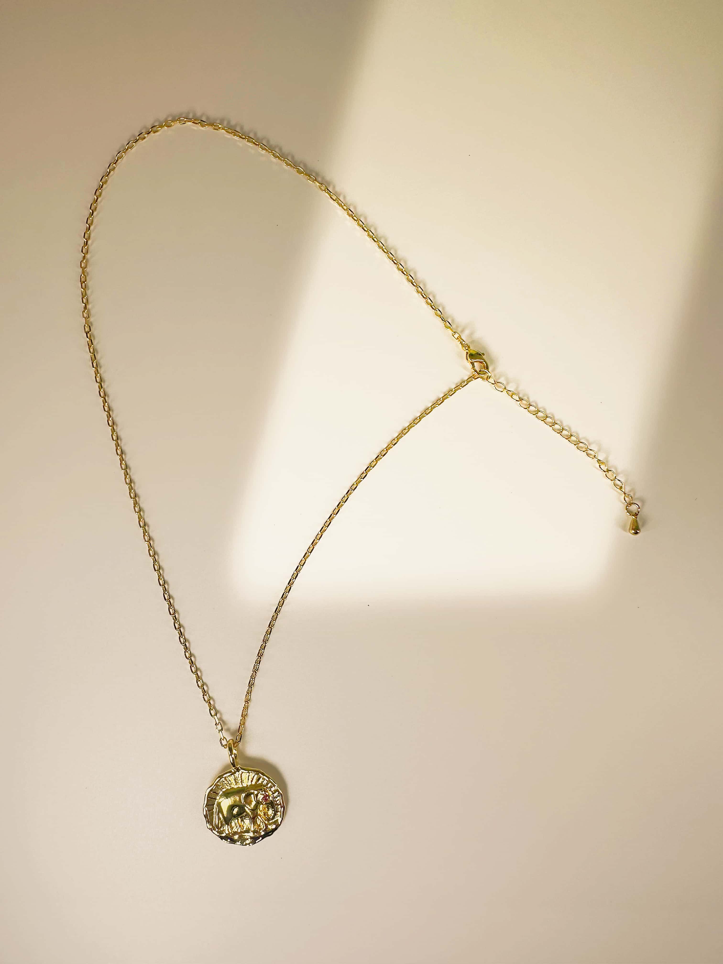 Full length view of the elephant necklace gold showcasing the delicate cable chain, lobster clasp, extender, and coin pendant