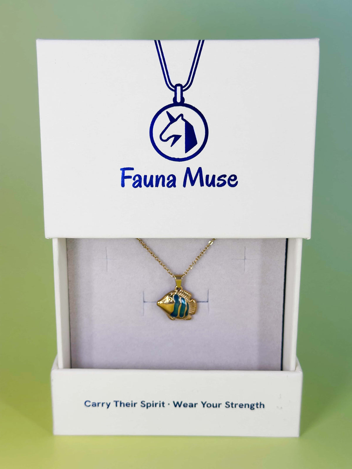 Fauna Muse gold tropical fish pendant necklace with blue enamel stripes displayed inside a white branded gift box