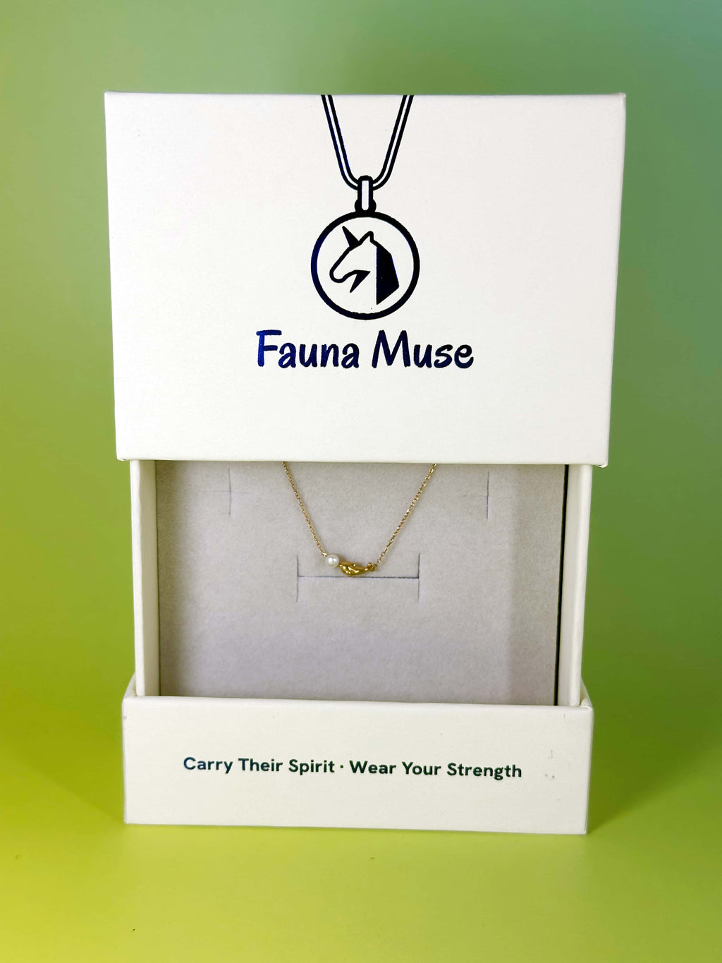 Fauna Muse gold dolphin pendant necklace with pearl displayed inside a white branded gift box