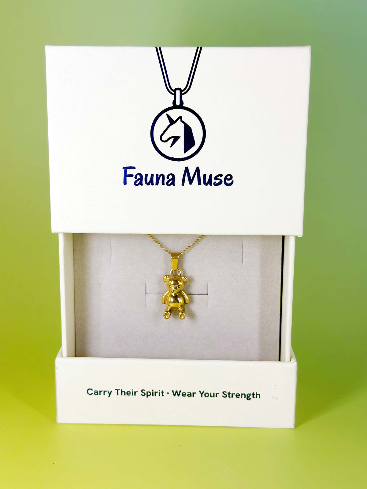 Fauna Muse gold teddy bear pendant necklace displayed inside a white branded gift box