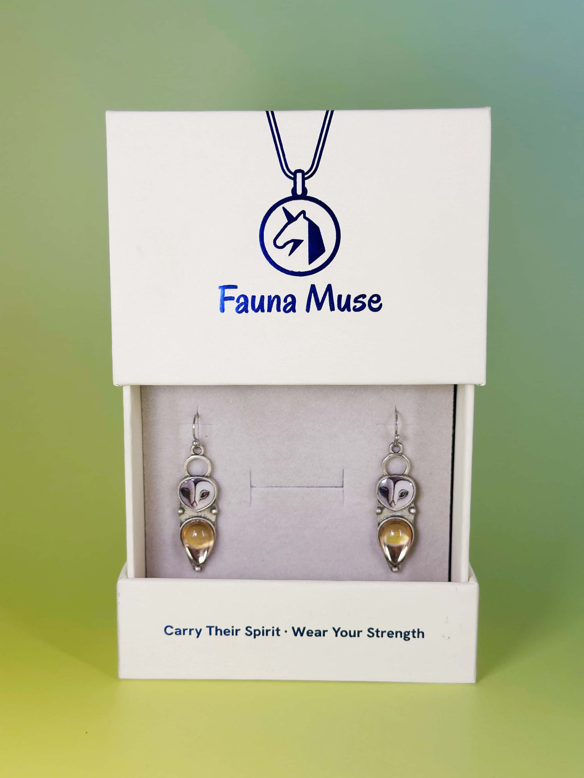 Fauna Muse owl drop earrings with amber teardrop stones displayed in a white branded jewelry gift box
