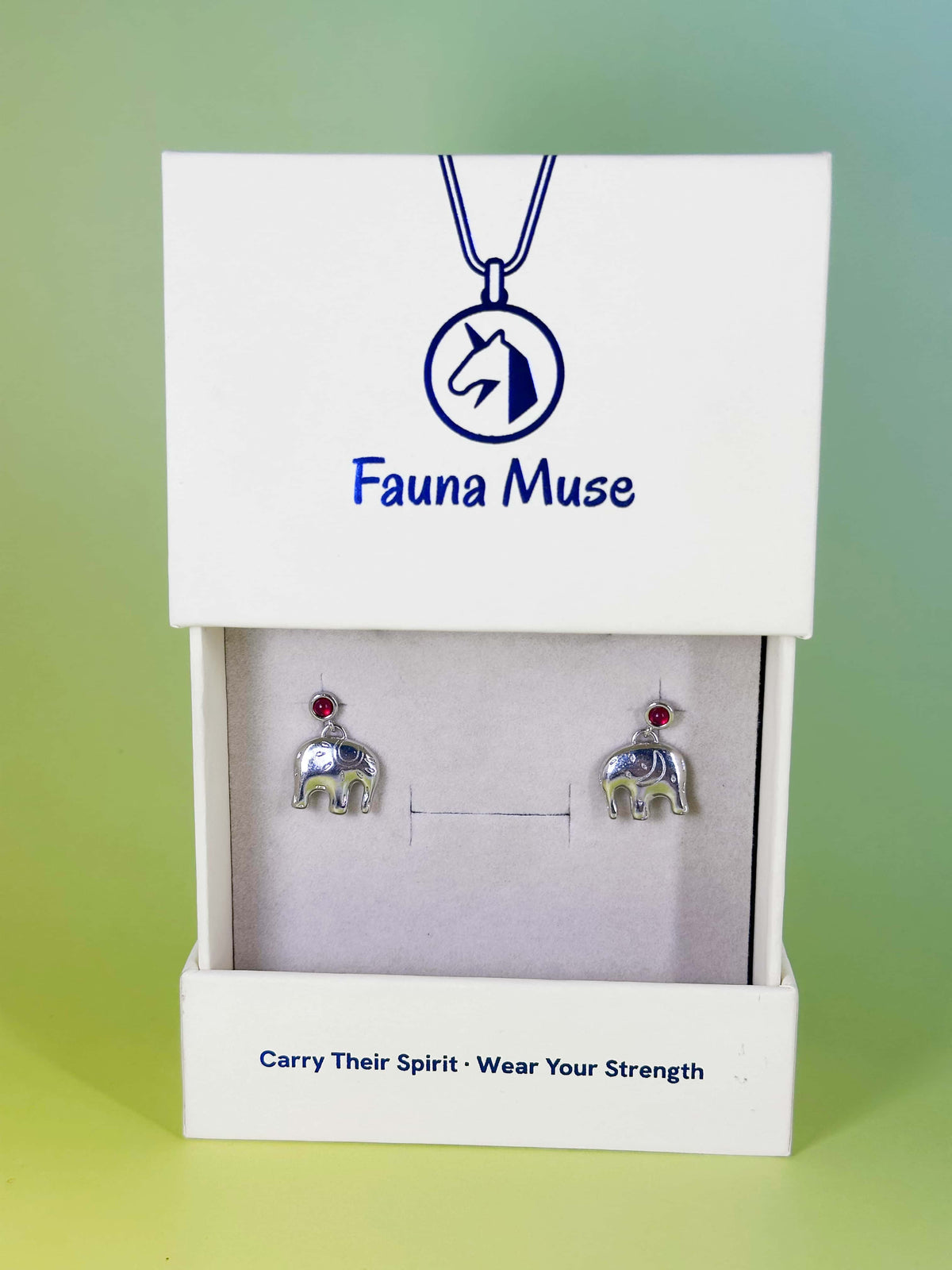 Fauna Muse silver elephant drop earrings with red gemstone accents displayed in a white branded jewelry gift box