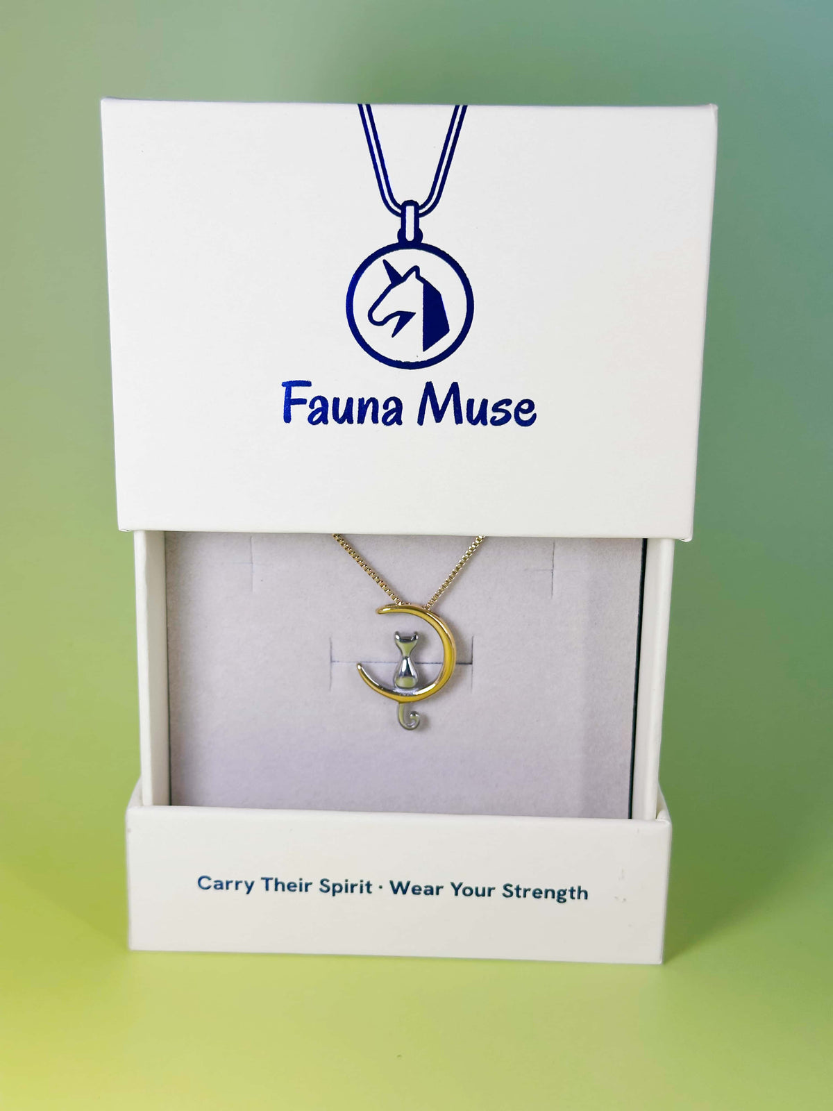 Fauna Muse two-tone silver and gold cat on crescent moon pendant necklace displayed inside a white branded gift box