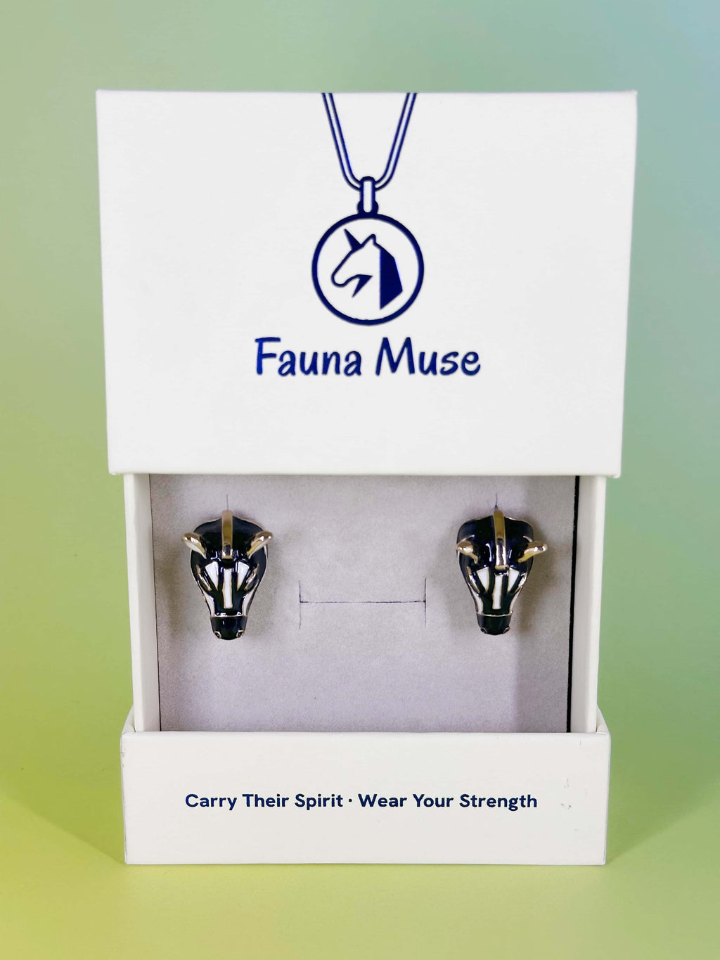 Fauna Muse black and white zebra stud earrings with gold accents displayed in a white branded jewelry gift box
