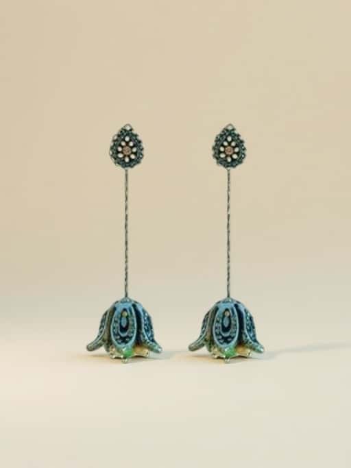 Pair of long earrings with floral designs on a beige background