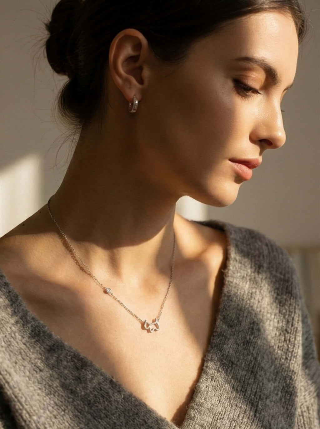 Side profile of an elegant woman wearing a stylish dog necklace, showcasing a beautiful jewelry piece perfect for gifts for dog moms.
