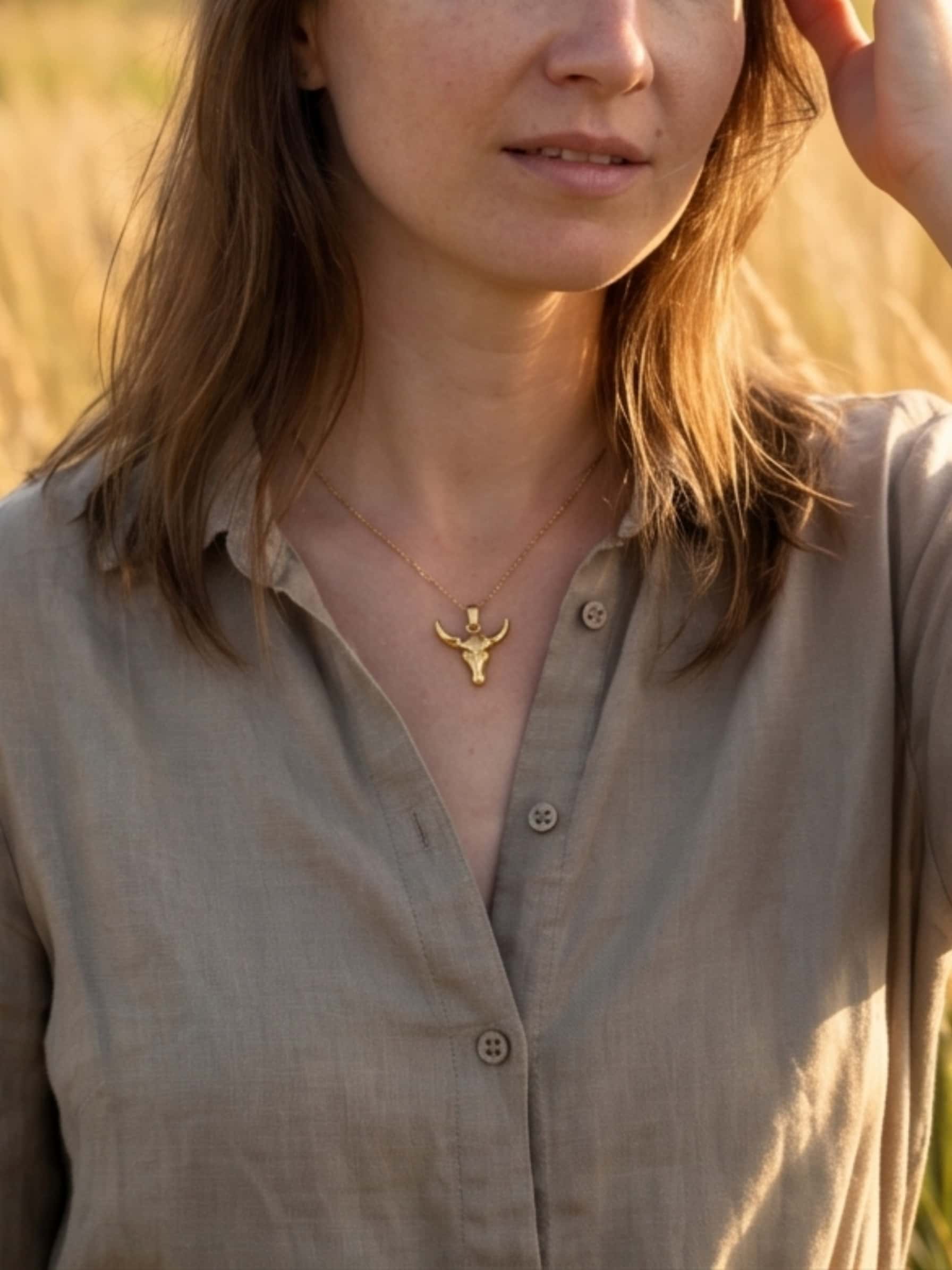 Lifestyle styling inspiration featuring the 18K gold plated bull necklace worn delicately on the neck