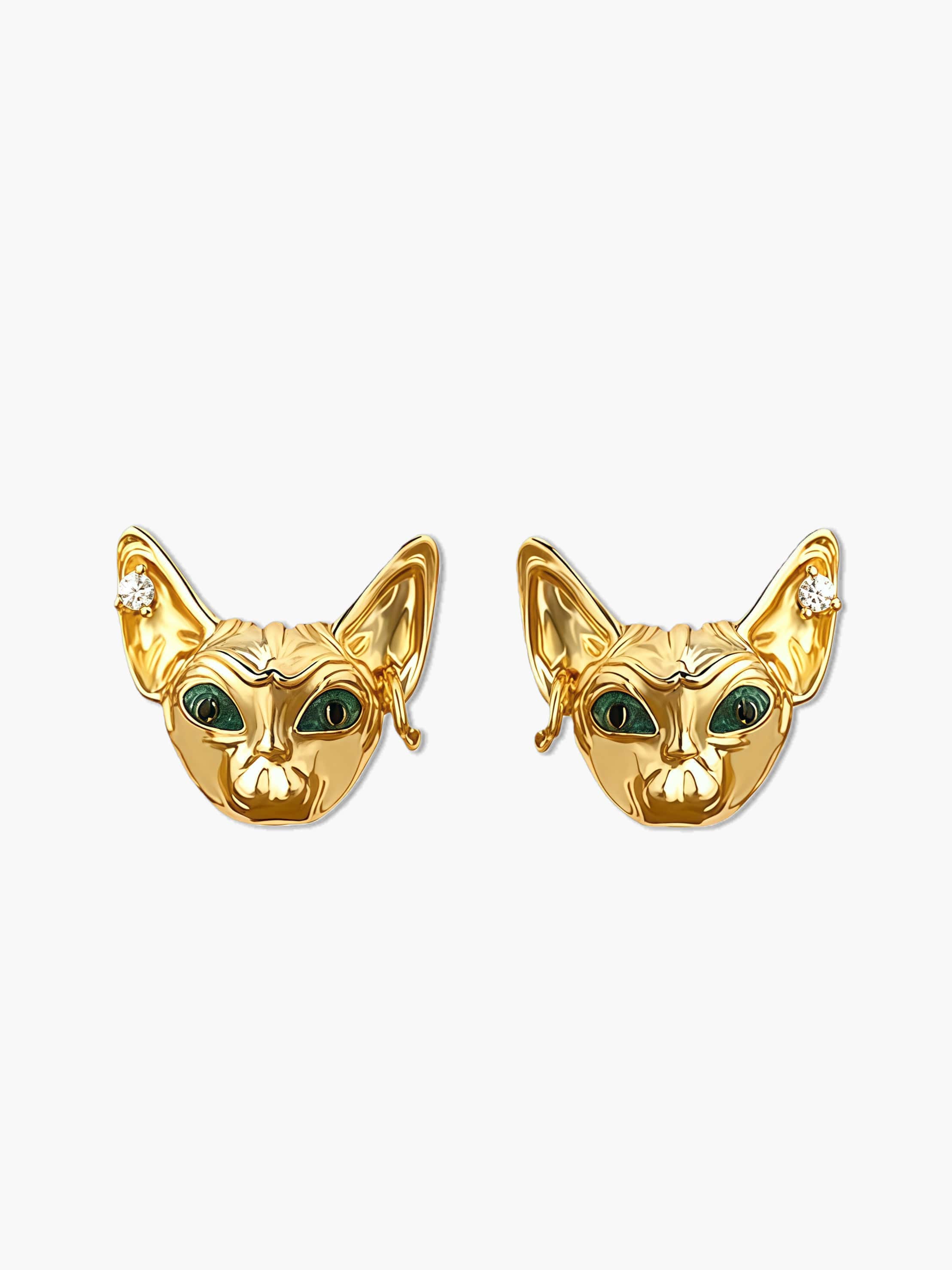 Gold cat earrings with green eyes on a white background