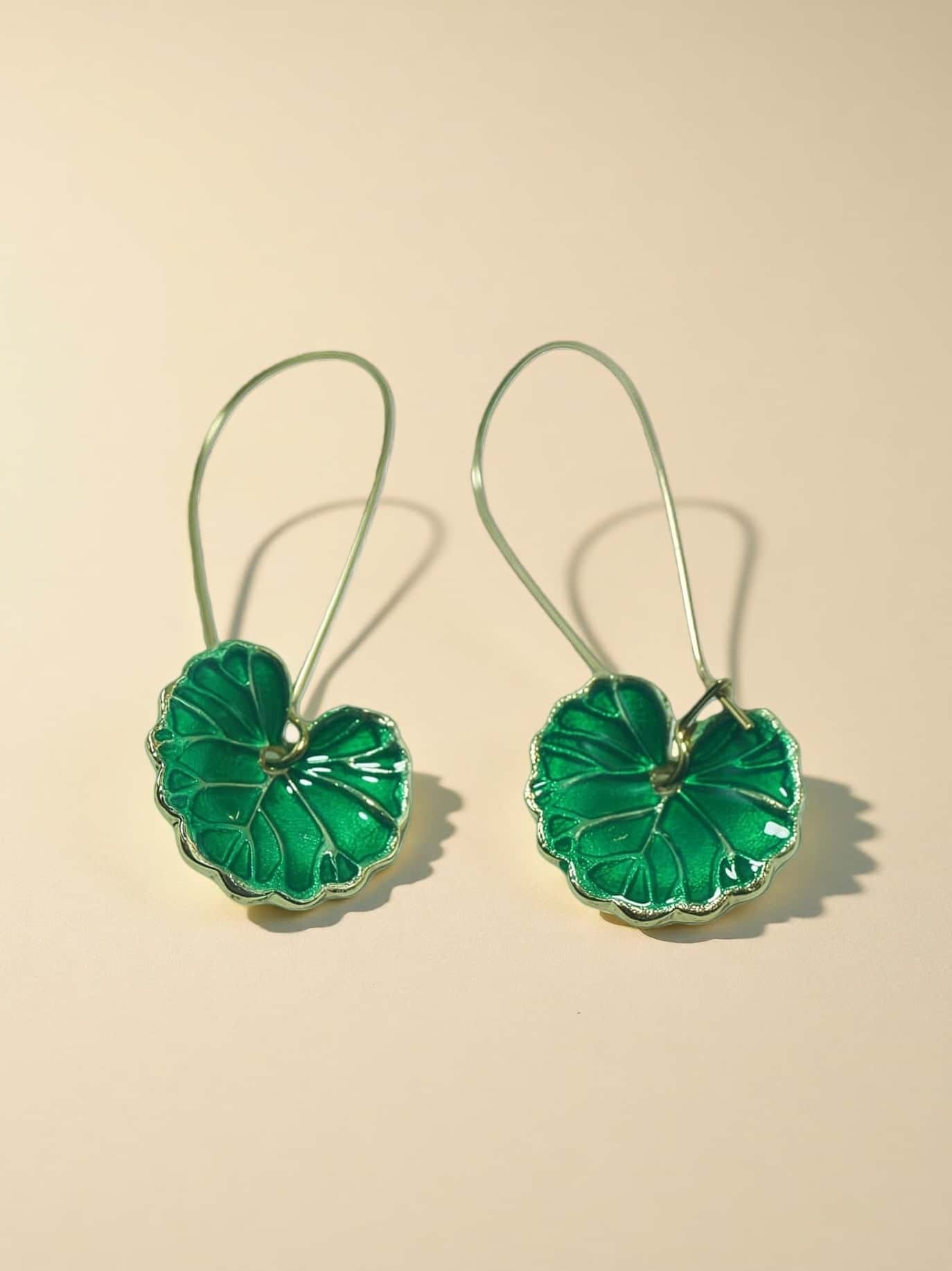 Pair of green floral earrings on a beige background