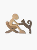 Front view of a minimalist wood sculpture featuring a human figure petting a cat, seamlessly interlocking light beech and dark walnut wood.