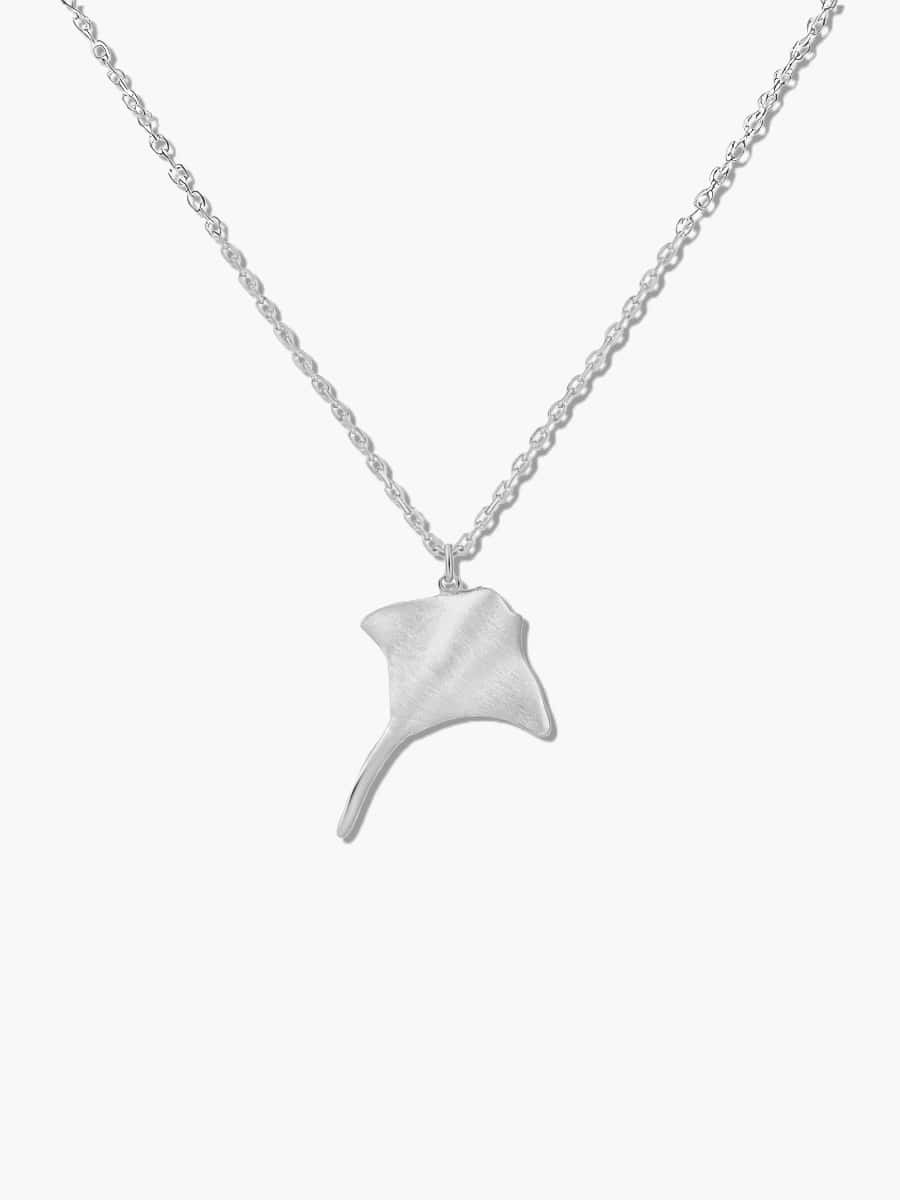 Silver manta ray pendant on a chain against a white background