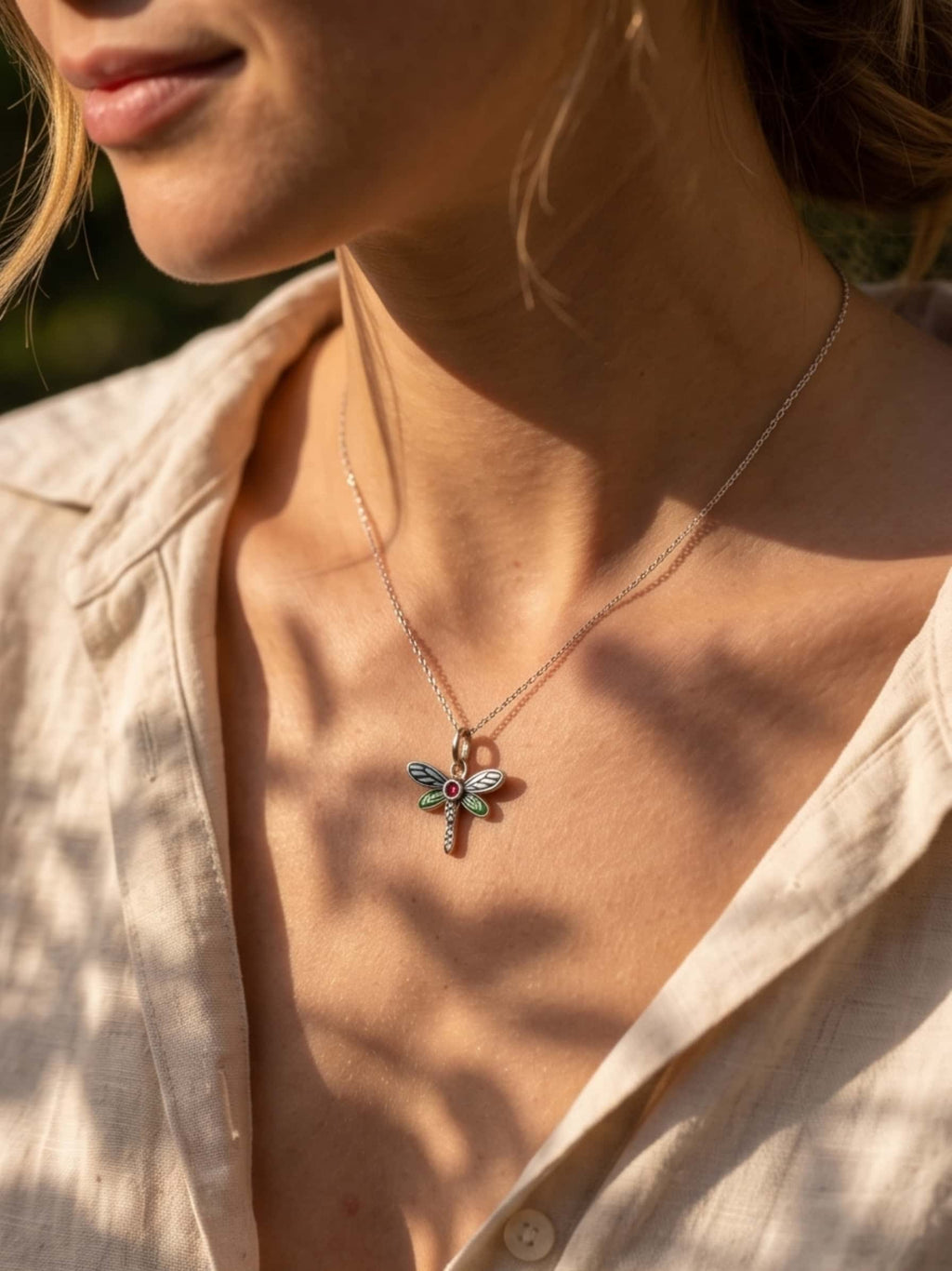 A stylish model showcasing a necklace dragonfly outdoors, demonstrating how the elegant pendant catches the sunlight
