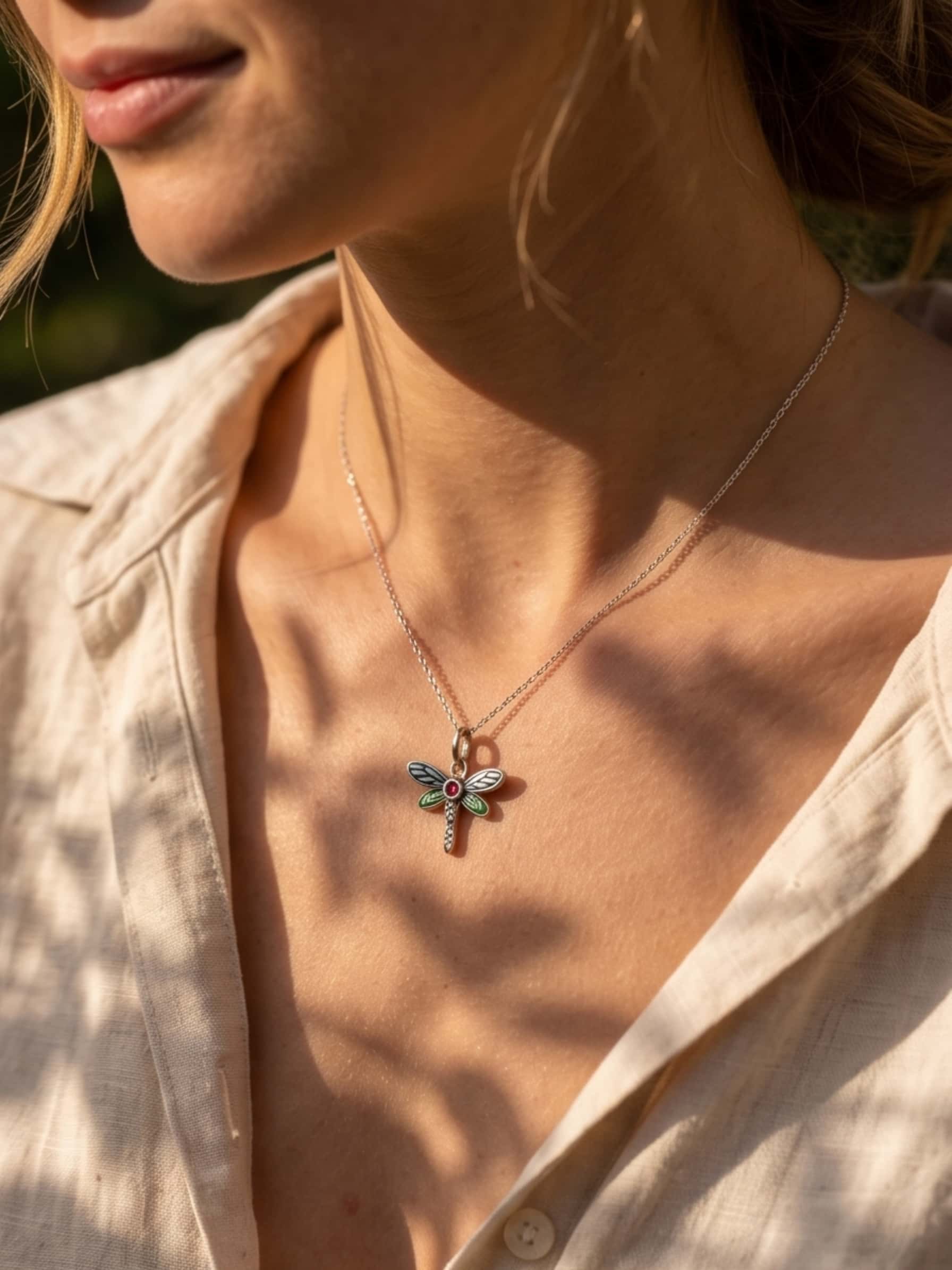 A stylish model showcasing a necklace dragonfly outdoors, demonstrating how the elegant pendant catches the sunlight