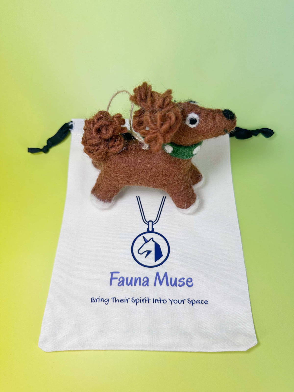 Handmade needle felted brown wool dog ornament wearing a green collar with Fauna Muse gift pouch