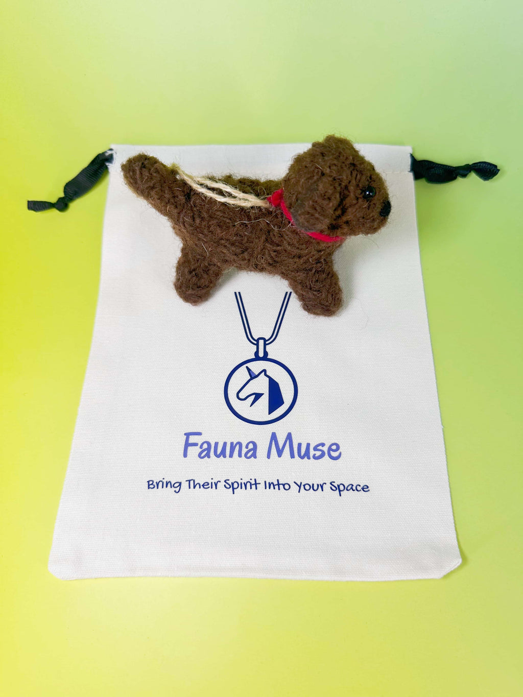 Handmade needle felted dark brown wool puppy dog ornament wearing a red collar with Fauna Muse gift pouch