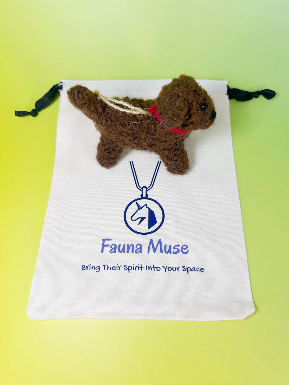 Handmade needle felted dark brown wool puppy dog ornament wearing a red collar with Fauna Muse gift pouch