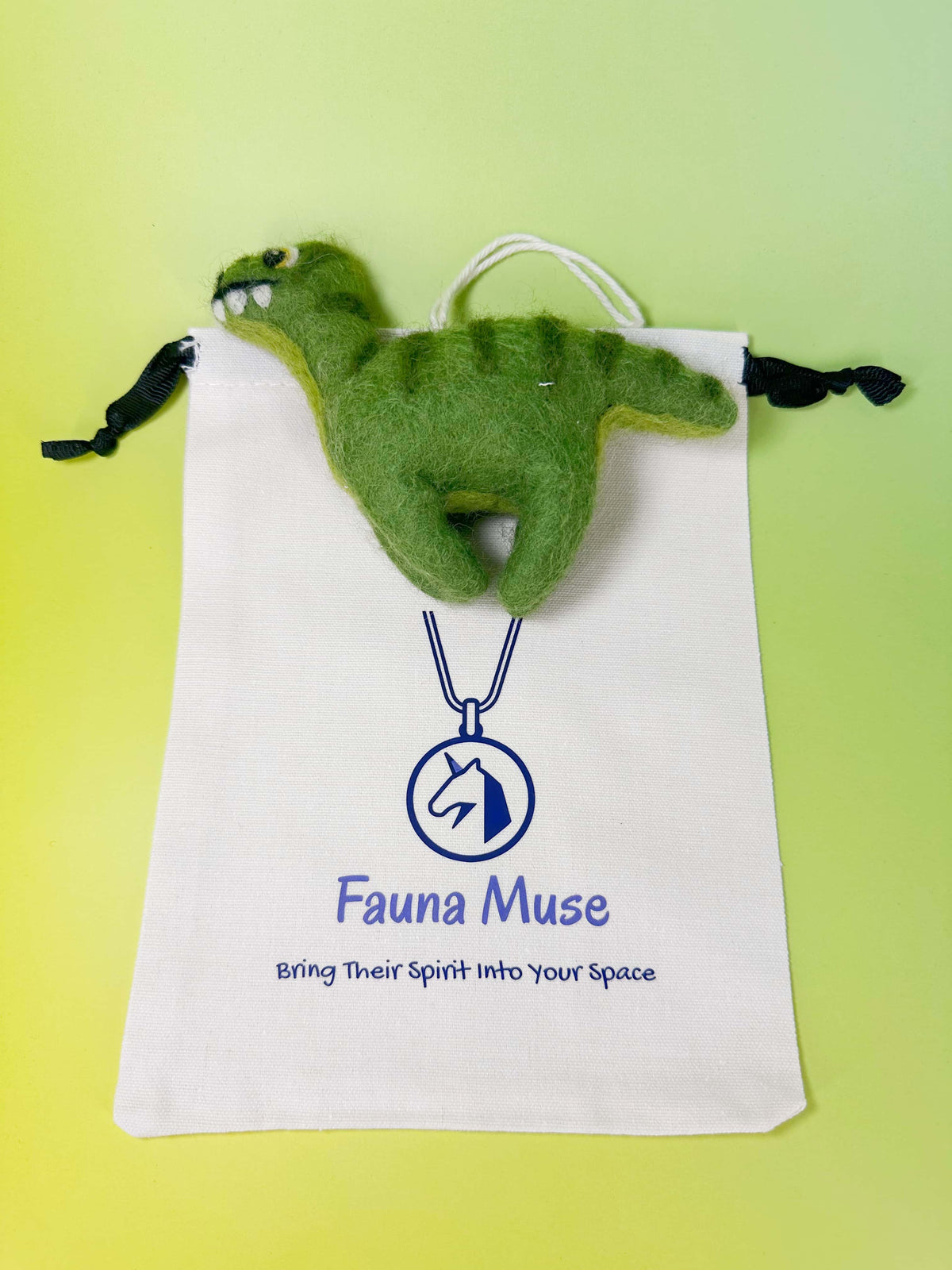 Handmade needle felted green wool dinosaur T-Rex ornament with hanging loop and Fauna Muse gift pouch