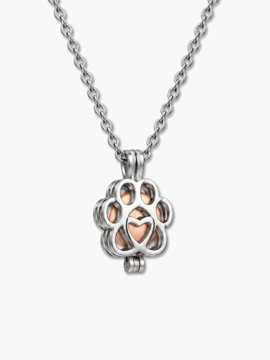 Close-up of a silver paw-shaped locket holding a rose gold pet urn necklace capsule for dog ashes