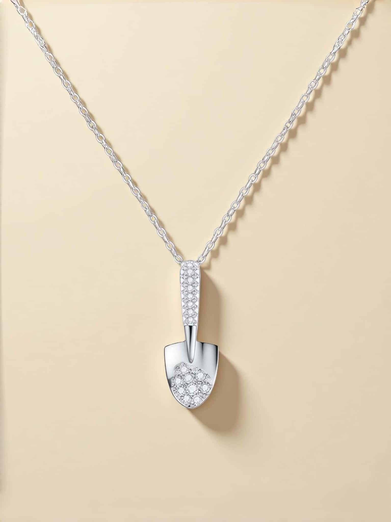 Silver necklace with a detailed pendant on a beige background