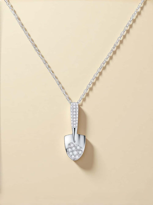 Silver necklace with a detailed pendant on a beige background