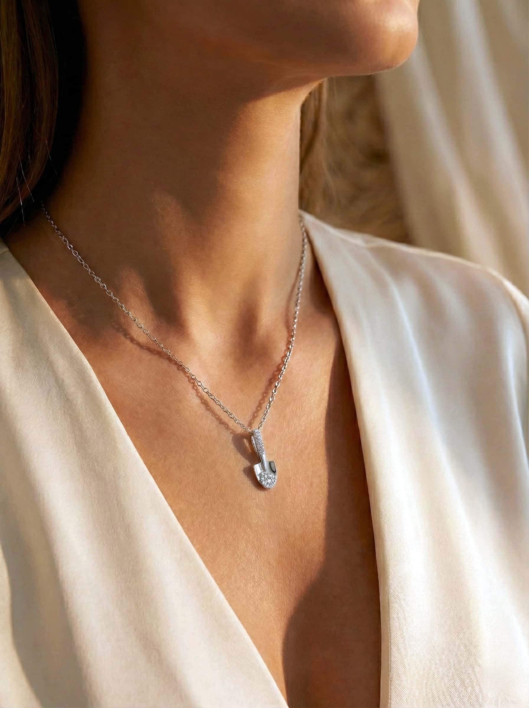 Necklace with a pendant worn by a person in a white garment