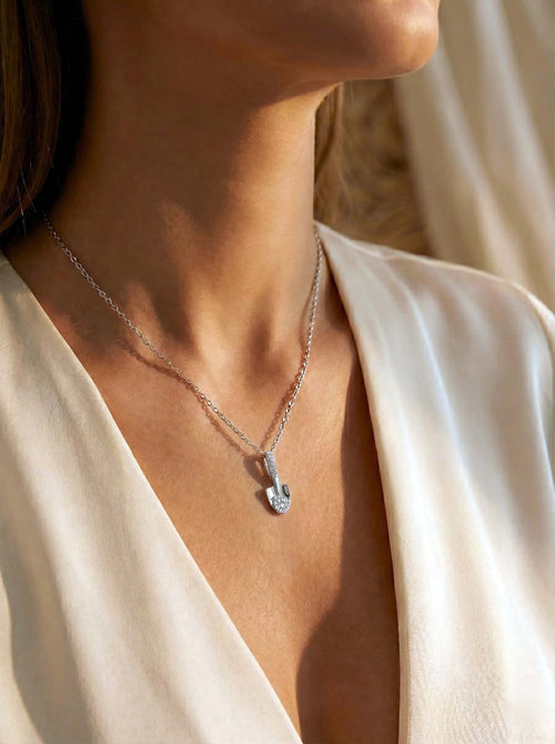 Necklace with a pendant worn by a person in a white garment