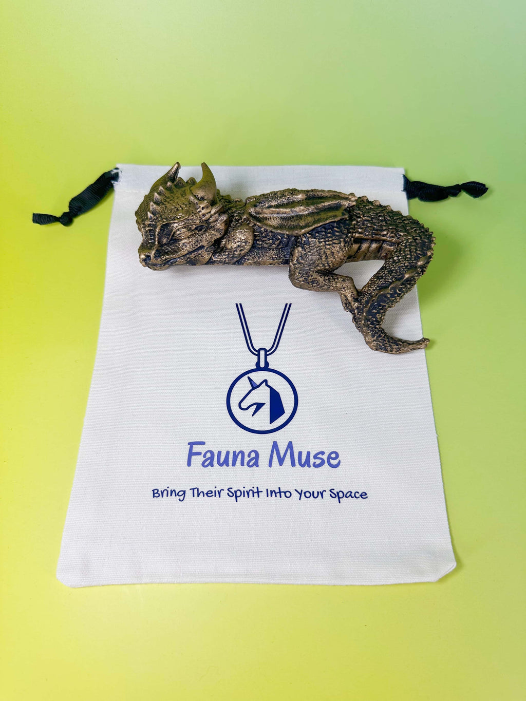 Fauna Muse sleeping dragon figurine with branded fabric gift pouch, showcasing the small dragon statue details