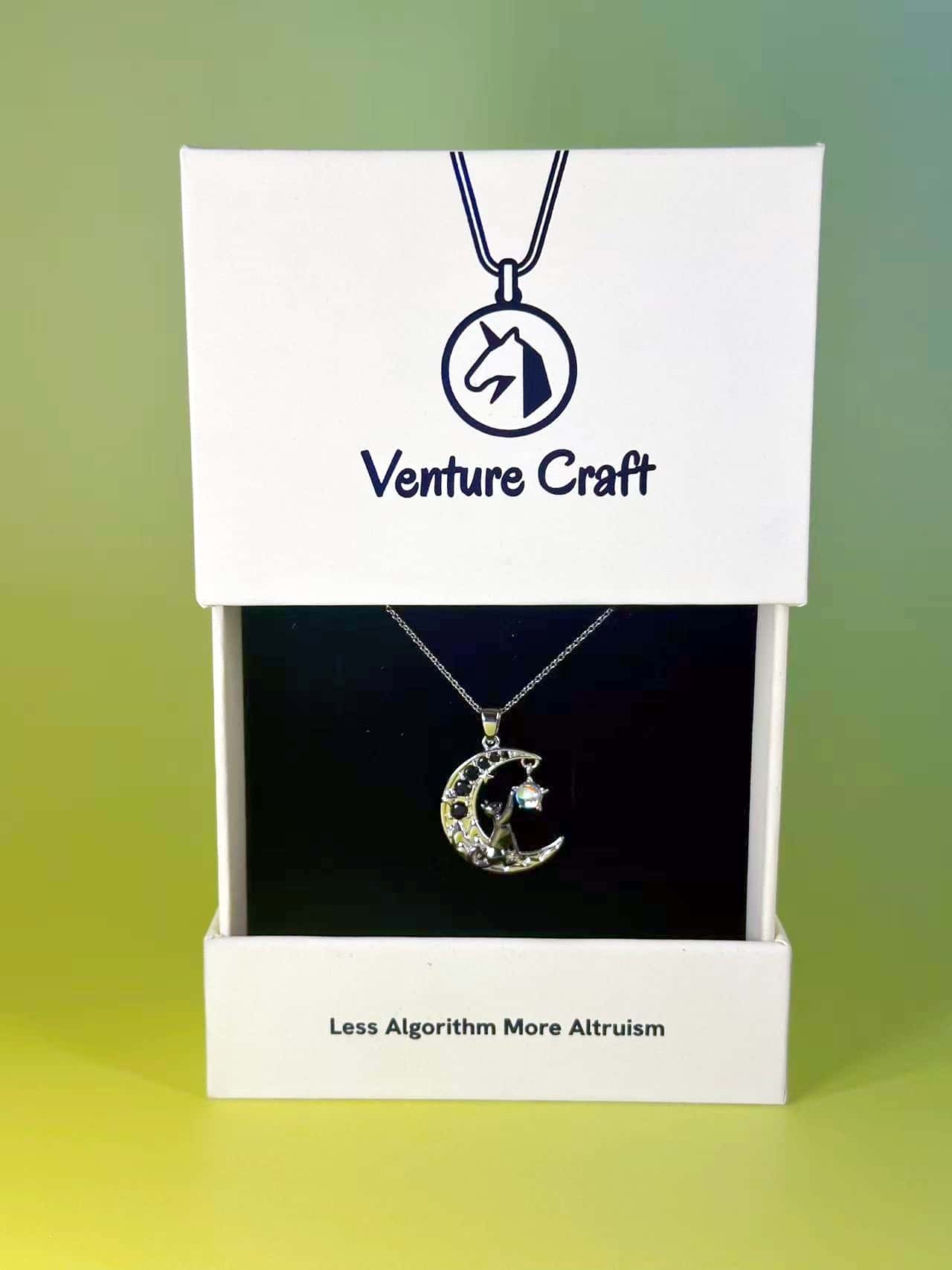 Venture Craft branded gift box displaying the celestial cat necklace with the brand slogan Less Algorithm More Altruism