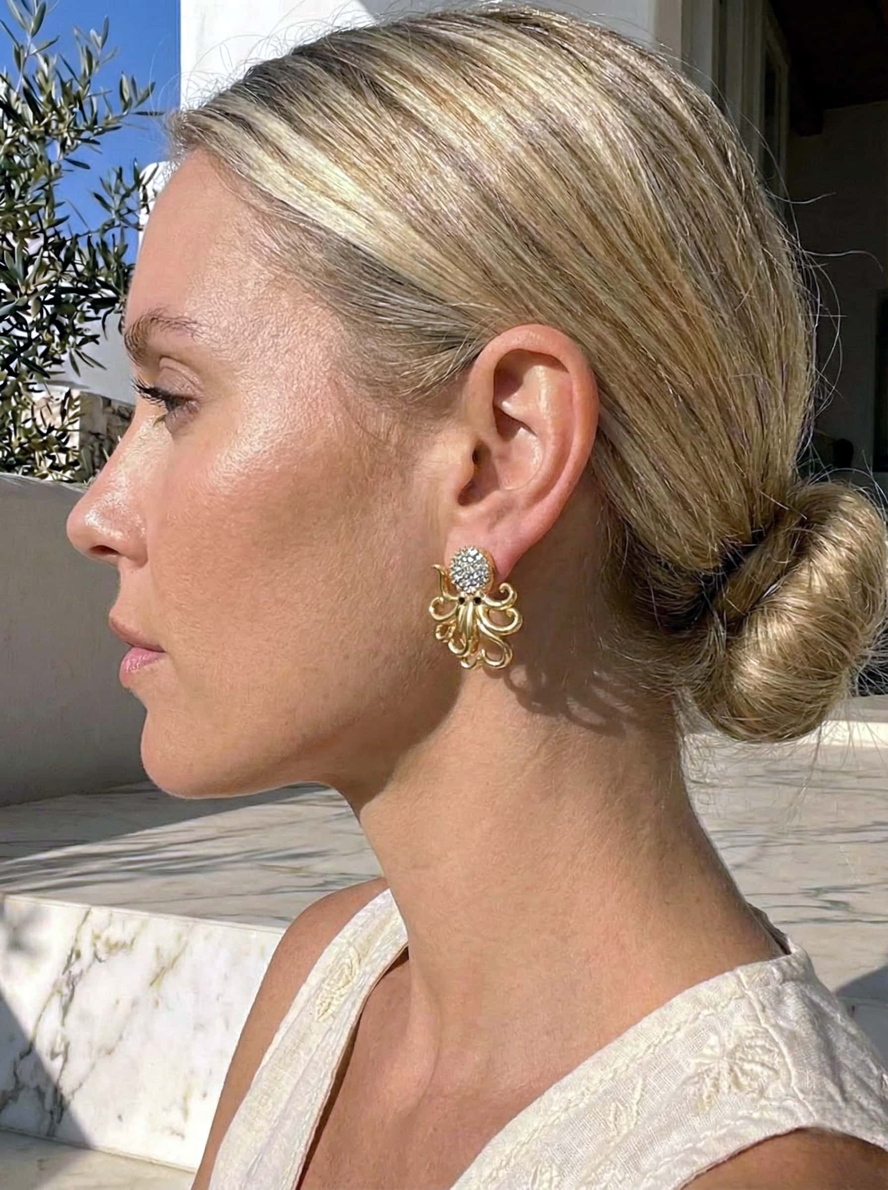 Woman with styled hair and octopus earrings  outdoors