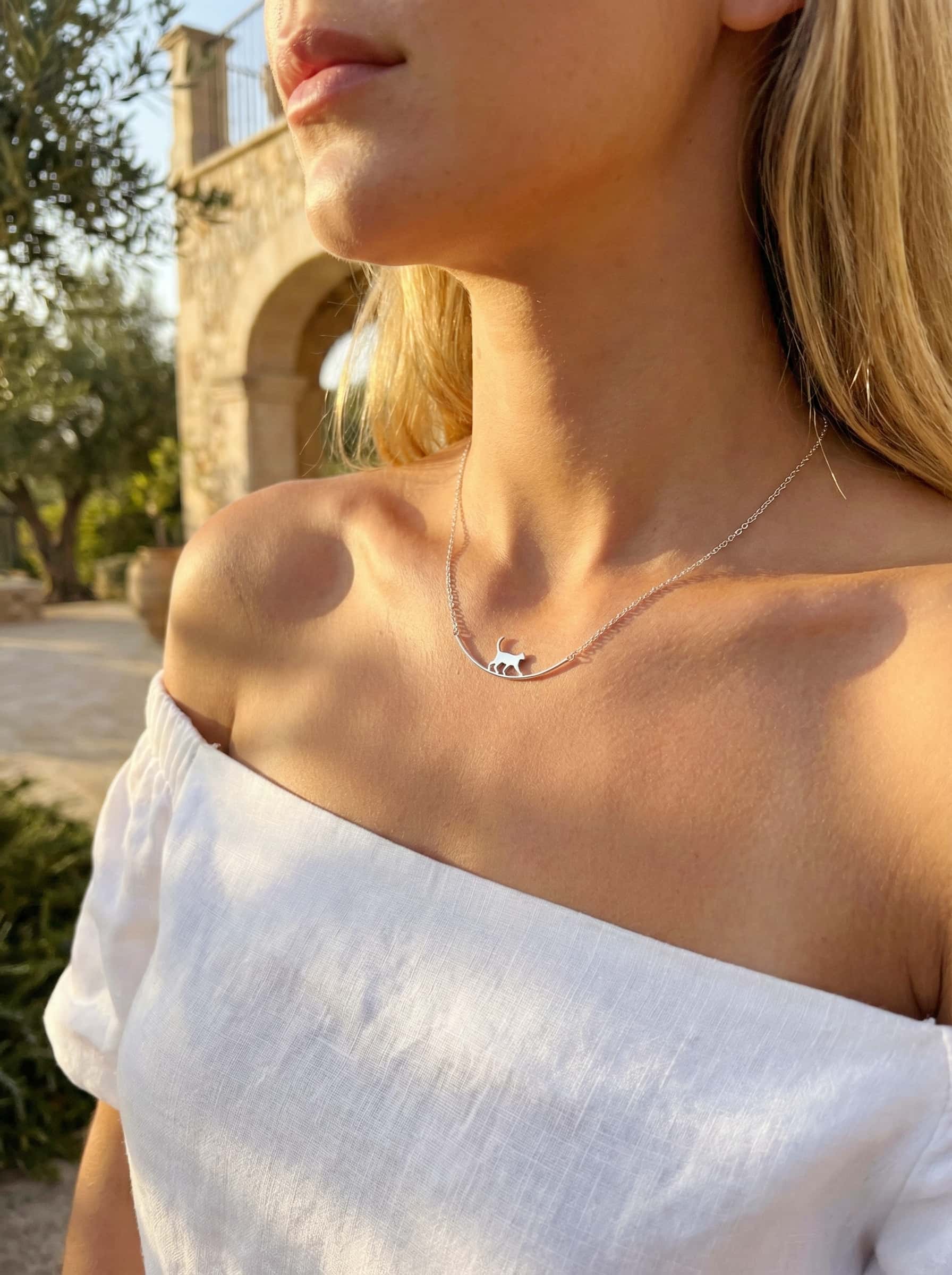 Woman wearing a delicate necklace with a scenic background